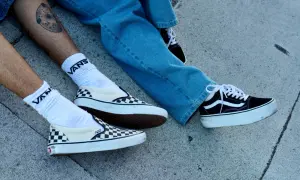 Due paia di Vans, una a scacchi e una nera con zeppa, pronte per essere lavate in lavatrice.