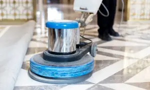 Macchina lucidatrice in azione su un pavimento in marmo. Un professionista sta lavorando per capire come pulire il marmo vecchio, riportandolo al suo antico splendore.