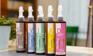 Cinque flaconi spray con etichette colorate: "S" (Formulatore Universale), "V" (Vetri Specchi), "I" (Igienizzante Bagno), "A" (Anticalcare), "D" (Detergente Multiuso). La differenza tra detergente e detersivo è chiara: qui sono tutti detergenti biologici.