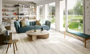 Soggiorno luminoso con divano blu e pavimento in gres porcellanato effetto legno, che mostra come rendere lucido il gres porcellanato effetto legno.
