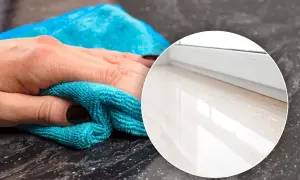 Mano che pulisce con panno azzurro il marmo dei davanzali, mostrando il risultato brillante.