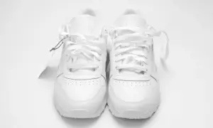Un paio di scarpe da ginnastica bianche, nuove di zecca, con etichetta. Chissà a quanti gradi si lavano le scarpe per mantenerle così immacolate.
