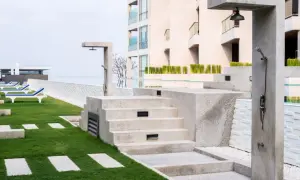 Docce esterne e gradinate in pietra, con un'area verde curata e lettini prendisole. Il trattamento marmo esterno valorizza l'ambiente.