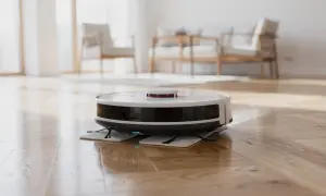 Robot lavapavimenti bianco e nero su parquet lucido. Non si può mettere alcool nel robot lavapavimenti.
