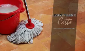 Secchio rosso con acqua saponata e uno straccio sul pavimento in cotto. Guida su come pulire pavimenti esterni ruvidi in cotto.