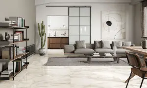 Pavimenti in splendidi tipi di marmo che riflettono la luce in un soggiorno moderno con divano grigio e libreria.