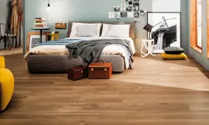 Camera da letto moderna con pavimento effetto legno, che ricorda i materiali lapidei per la sua resistenza e bellezza.