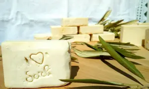 Sapone artigianale, frutto della saponificazione olio di oliva, con decorazione a cuore e scritta "Sich". Foglie d'ulivo completano la scena.