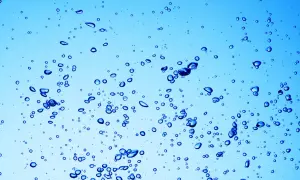 Bollicine blu in acqua chiara, un'immagine che ricorda a cosa serve l'acqua ossigenata: per pulire e disinfettare.