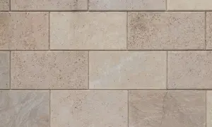 Dettaglio di un pavimento in trachite, con blocchi rettangolari di pietra chiara, alcuni con venature naturali e piccole inclusioni.