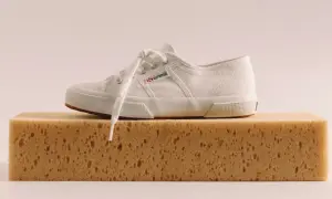 Scarpa bianca Superga su una spugna, pronta per lavare Superga in lavatrice.