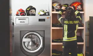 Vigile del Fuoco sistema i caschi accanto a una lavatrice industriale, pronta per il lavaggio abiti da lavoro.