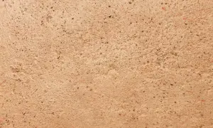 Dettaglio di un antico cocciopesto pavimento, con frammenti di terracotta e pietre che creano una texture rustica e calda.