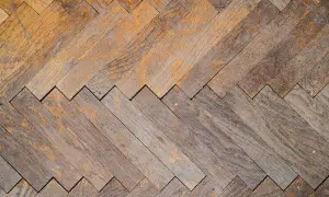 Parquet in legno con motivo a spina di pesce, usurato ma pronto per essere lucidato con rimedi della nonna per farlo brillare.