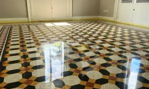 Pavimento in graniglia con motivo geometrico dai colori vivaci, reso brillante dalla lucidatura.
