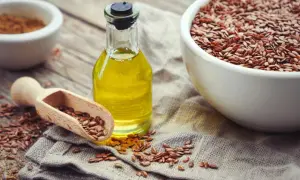 Olio di lino per pavimenti in graniglia, con semi sparsi e una ciotola piena.