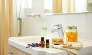 Lavanda, oli essenziali, spazzola e arance in barattolo sul lavandino. Un bagno pulito e profumato, non un bagno sporco.