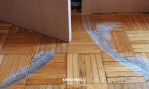 Parquet rovinato, pronto per il rinnovo. Segni evidenti di usura e graffi sul legno, in attesa di nuova vita.