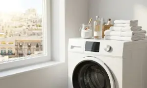Lavatrice bianca con prodotti per disinfettare lavatrice aceto e bicarbonato. Asciugamani bianchi piegati in cima.