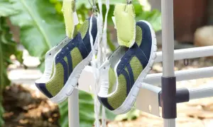 Scarpe sportive verdi e blu appese ad asciugare all'aperto, un metodo efficace per capire come lavare le scarpe dentro e farle tornare come nuove.