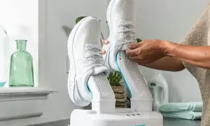 Come asciugare le scarpe da ginnastica: un dispositivo bianco con due stivali da corsa bianchi inseriti, pronto per l'asciugatura.