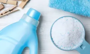 Detersivo in polvere in un misurino accanto a una bottiglia di detersivo liquido. Qual è meglio detersivo in polvere o liquido?