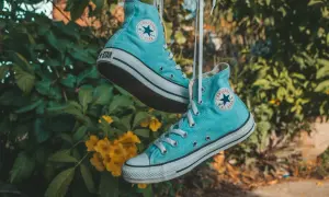 Scarpe All Star azzurre appese, pronte per essere lavate in lavatrice.