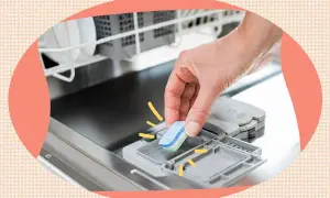 Mano inserisce un detersivo lavastoviglie direttamente nel cestello.