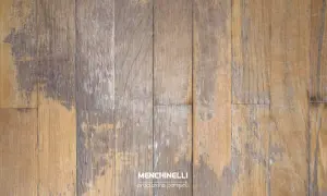 Parquet rovinato dall'acqua, con doghe in legno che mostrano macchie scure e usura, testimoni di un passato umido.