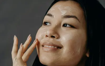 Donna applica una maschera sul viso, un gesto quotidiano per imparare come curare la pelle del viso e renderla luminosa.