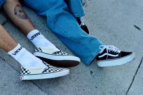 Due paia di Vans, una a scacchi e una nera con zeppa, pronte per essere lavate in lavatrice.