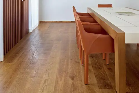 Un elegante parquet rovere naturale, con le sue venature calde, pronto per essere pulito con cura.