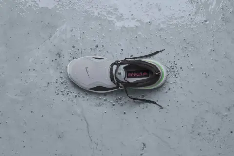 Scarpa da running Nike grigia, bagnata e sporca, pronta per essere messa in asciugatrice per un rapido recupero.