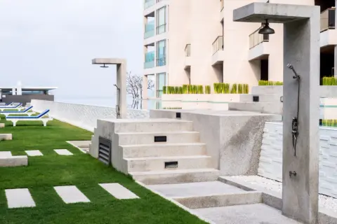 Docce esterne e gradinate in pietra, con un'area verde curata e lettini prendisole. Il trattamento marmo esterno valorizza l'ambiente.