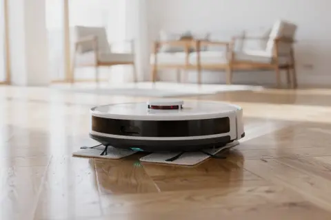 Robot lavapavimenti bianco e nero su parquet lucido. Non si può mettere alcool nel robot lavapavimenti.