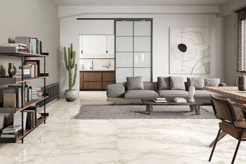 Pavimenti in splendidi tipi di marmo che riflettono la luce in un soggiorno moderno con divano grigio e libreria.