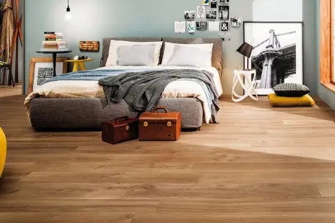 Camera da letto moderna con pavimento effetto legno, che ricorda i materiali lapidei per la sua resistenza e bellezza.