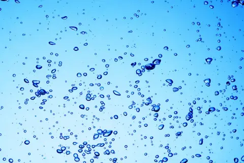 Bollicine blu in acqua chiara, un'immagine che ricorda a cosa serve l'acqua ossigenata: per pulire e disinfettare.