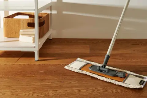 Mocio pronto per pulire pavimento marmo molto sporco. Sulla mensola, una cesta in legno e saponi.