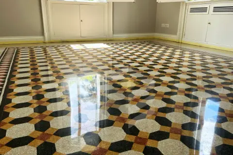 Pavimento in graniglia con motivo geometrico dai colori vivaci, reso brillante dalla lucidatura.