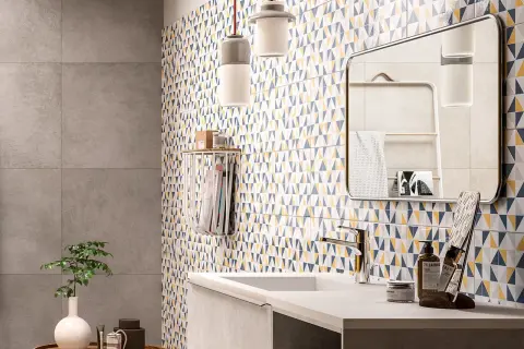 Bagno moderno con parete a triangoli colorati, ideale per chi cerca idee su come rinnovare pavimento in ceramica con stile.