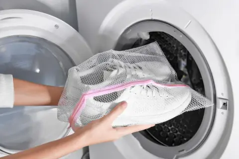Come lavare le scarpe da trekking in lavatrice: inserisci le scarpe in una sacca a rete prima di metterle nell'oblò.