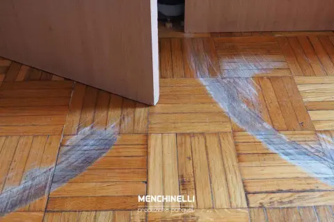 Parquet rovinato, pronto per il rinnovo. Segni evidenti di usura e graffi sul legno, in attesa di nuova vita.