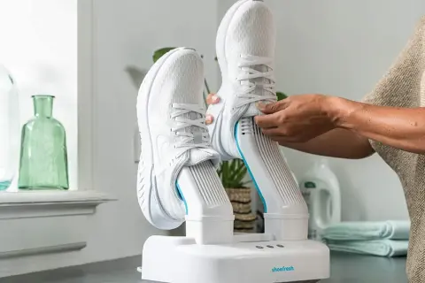 Come asciugare le scarpe da ginnastica: un dispositivo bianco con due stivali da corsa bianchi inseriti, pronto per l'asciugatura.