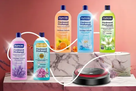 Linee di detersivi Nuncas Pavimenti Profumati, detersivi senza sbiancanti ottici, con fragranze lavanda, agrumi, fiorito e zagara, accanto a un robot aspirapolvere.