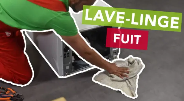 Un tecnico con tuta rossa e verde asciuga con uno straccio il pavimento dove la lavatrice perde acqua dal cestello.