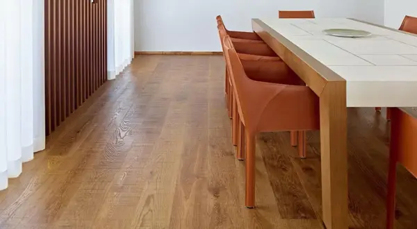 Un elegante parquet rovere naturale, con le sue venature calde, pronto per essere pulito con cura.