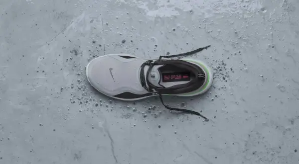 Scarpa da running Nike grigia, bagnata e sporca, pronta per essere messa in asciugatrice per un rapido recupero.