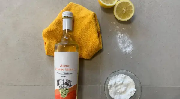 Aceto di vino bianco, bicarbonato, limoni e un panno giallo per lavare i pavimenti con aceto e ammorbidente.