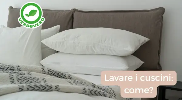 Bianchi cuscini su un letto, con un logo "Verdevero". Impara come lavare i cuscini in lavatrice per mantenerli freschi e puliti.